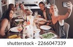 Selfie, dinner and party with friends eating food together for a new year celebration or event. Home, feast and meal with a man and woman friend group sitting at a table for a social gathering