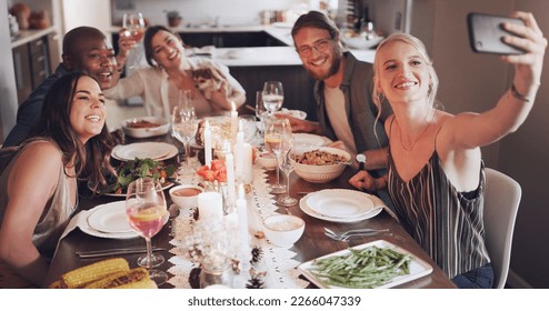 Selfie, dinner and party with friends eating food together for a new year celebration or event. Home, feast and meal with a man and woman friend group sitting at a table for a social gathering - Shutterstock ID 2266047339