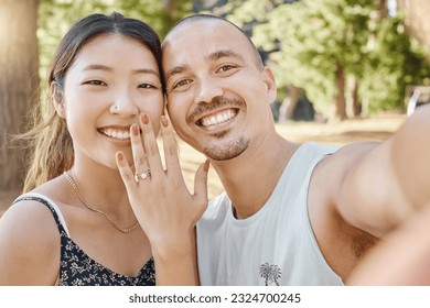 Selfie, engagement and portrait of couple in nature by outdoor park, garden or woods. Happy, smile and interracial engaged man and woman taking picture after romantic proposal with love and happiness - Powered by Shutterstock