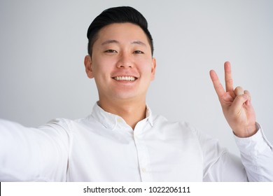 Selfie of Happy Asian Guy with Peace Gesture