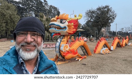Selfie of an old man with gray beard with Chinese Dragon in the background in Ratna patk, Kathmandu, Nepal. Stock fotó © 