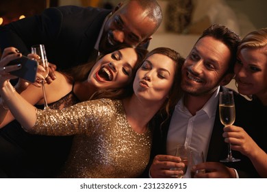 Selfie, party and new year with friends in a club posing for photograph of celebration together. Champagne, toast and nightlife with a group of people taking a picture in a nightclub while dancing - Powered by Shutterstock