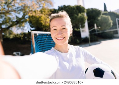 selfie photo of smiling woman holding soccer ball - Powered by Shutterstock