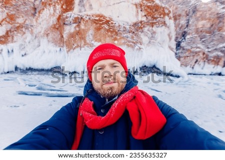 Selfie photo tourist in winter on background of frozen waterfall in Iceland or Norway.