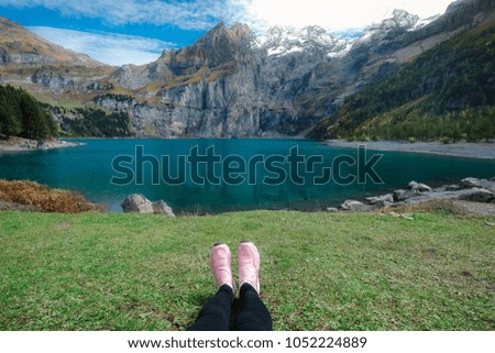 Selfie pink sneakers while sitting on Oeschinensee lake mountain background, Kanderstag Switzerland concept for relaxing, summer vacation activity, day off, hiking sports