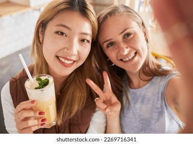 Selfie, portrait or friends take profile picture in cafe with happy smile on holiday vacation or weekend. Social media, Asian or young women smiling in restaurant for fun brunch date with cocktails - Powered by Shutterstock