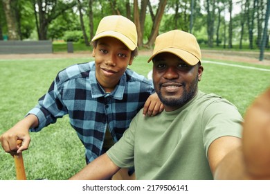 Selfie Portrait Of Happy Dad And Son In Caps During Their Game In Baseball In Park Outdoors