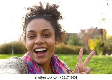 Selfie Portrait Of A Happy Young Woman With Peace Sign