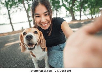 Selfie portrait of young asian woman with her beagle dog, in the park in summer. - Powered by Shutterstock