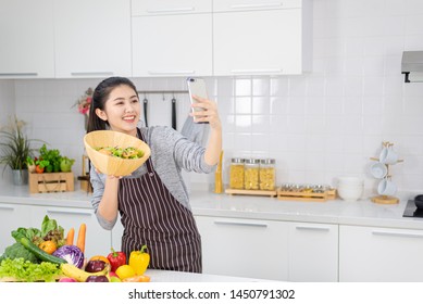 Selfie with a salad in a modern kitchen,Beautiful woman taking selfies while cooking in the modern kitchen. Healthy food and fasting concepts - Powered by Shutterstock