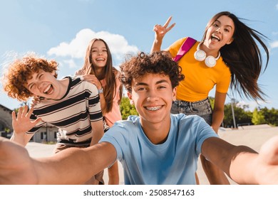 Selfie shot of crazy young people friends college students school pupils classmates teenagers having fun together spend time summer weekend in skate park outside urban street. Friendship concept - Powered by Shutterstock