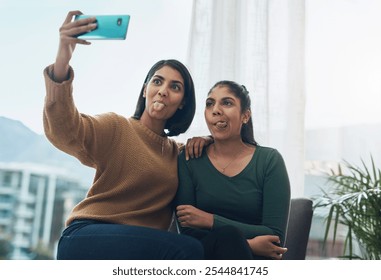 Selfie, smile and tongue out with sisters in living room of home together for bonding, love or memories. App, funny face or profile picture with girl siblings in city apartment for photograph - Powered by Shutterstock