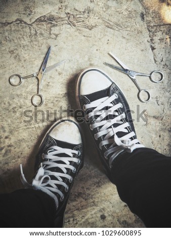 Selfie of sneakers with hair cutting shears