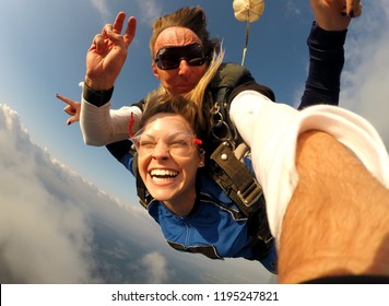 Selfie tandem skydiving with pretty woman