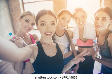 Selfie Time, Girls! Five Girlfriends In Fashionable Sport Outfits Are Posing For A Selfie Photo, That Asian Brunette Is Taking. They Are All Smiling, Joyful After The Workout