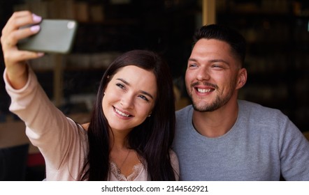 Selfie Time With My Favourite Person. Cropped Shot Of A Young Couple Taking A Selfie While Sitting Together.