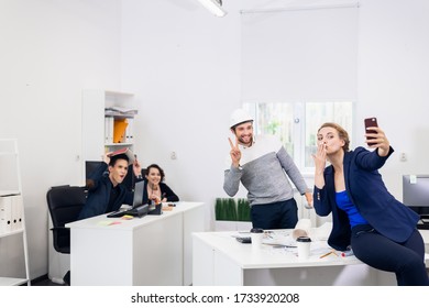 Selfie time. Office workers taking selfies at work - Shutterstock ID 1733920208