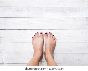 Selfie Woman Feet With Dark Red Nails On White Vintage Wood White Background.
