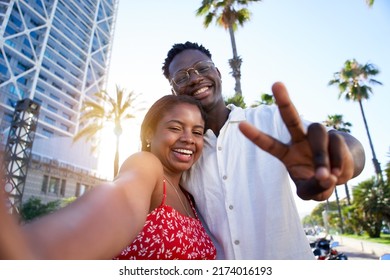 Selfie of a young black couple looking at camera smiling. Concept of vacation and relationship. African American couple having fun enjoying holidays - Powered by Shutterstock