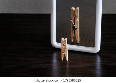 selfish concept. small clothespin seeing himself in the mirror as big king with crown - Shutterstock ID 1795588825