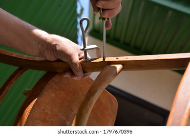 A Self-isolation Class Is A Chair Repair. Grandfather Repairs A Chair On The Street, Using Screws, Glue, And A Vice.