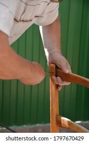 A Self-isolation Class Is A Chair Repair. Grandfather Repairs A Chair On The Street, Using Screws, Glue, And A Vice.