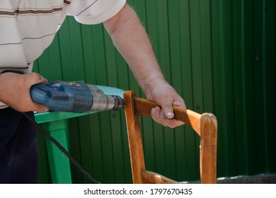 A Self-isolation Class Is A Chair Repair. Grandfather Repairs A Chair On The Street, Using Screws, Glue, And A Vice.