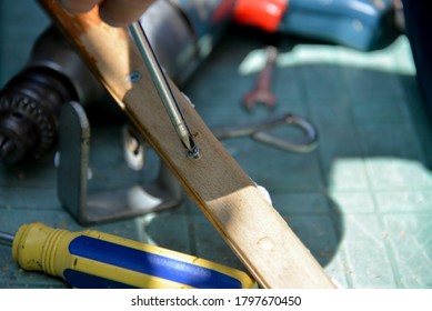 A Self-isolation Class Is A Chair Repair. Grandfather Repairs A Chair On The Street, Using Screws, Glue, And A Vice.