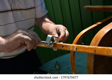 A Self-isolation Class Is A Chair Repair. Grandfather Repairs A Chair On The Street, Using Screws, Glue, And A Vice.