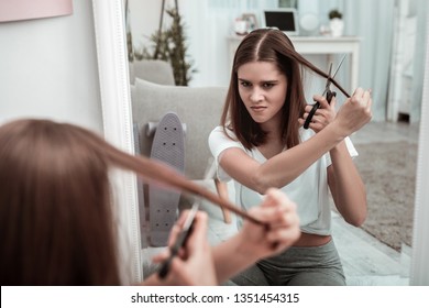 Self-made Haircut. A Woman Attempting To Cut Her Hair Herself