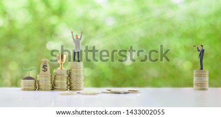 Self-made millionaire  become a billionaire from nothing, story of successful leader concept : Business tycoon raise hand to show dignity, trophy cup of winner, dollar bag, growing small tree on coin