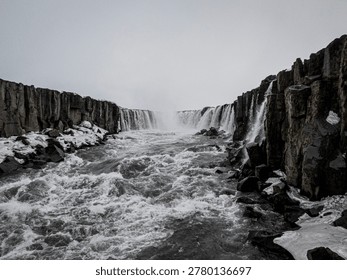 Selfoss waterfall cascading over basalt cliffs with a powerful glacial river flowing through jokulsargljufur canyon