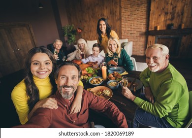 Self-portrait of attractive cheerful family brother sister gathering eating festal luncheon meal dish autumn fall harvest celebration embracing at modern loft brick wooden industrial interior
