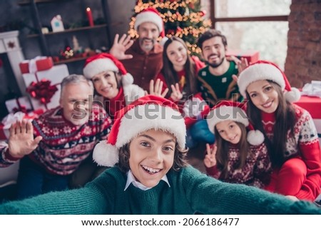 Self-portrait of attractive cheerful family waving hello greetings having fun eve advent party time at home indoors