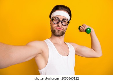 Self-portrait Of Attractive Funky Guy Nerd Doing Work Out Body Building Isolated Over Bright Yellow Color Background