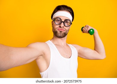 Self-portrait Of Attractive Funky Guy Nerd Doing Work Out Body Building Isolated Over Bright Yellow Color Background