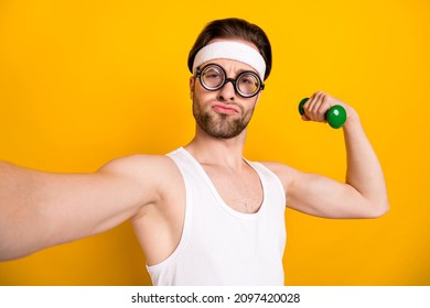 Self-portrait Of Attractive Funky Guy Nerd Doing Work Out Body Building Isolated Over Bright Yellow Color Background