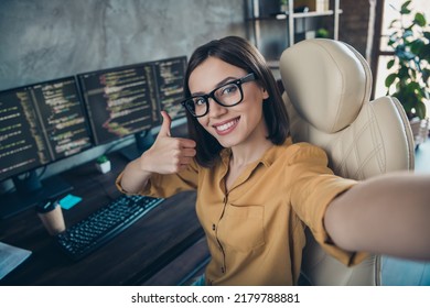 Self-portrait Of Attractive Smart Clever Cheerful Girl Cyber Engineer Showing Thumbup Solution At Workplace Workstation Indoors