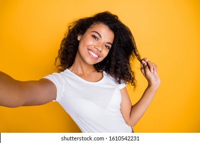 Self-portrait of her she nice attractive lovely charming cute winsome sweet cheerful cheery wavy-haired girl playing with curl flirting isolated over bright vivid shine vibrant yellow color background