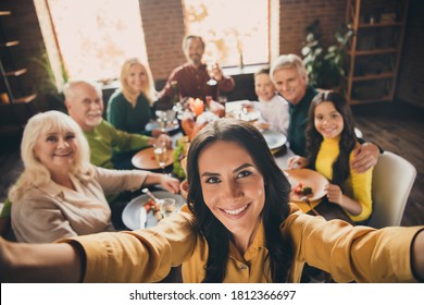 Self-portrait of nice attractive cheerful big full family brother sister gathering parents grandparents eating homemade meal festal autumn fall November at modern loft brick industrial interior