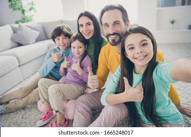 Self-portrait of nice attractive lovely glad big full cheerful cheery family pre-teen kids mom dad showing thumbup at light white interior style house apartment living-room - Powered by Shutterstock