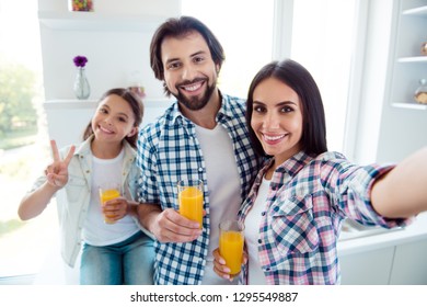 Self-portrait of nice cute sweet lovely attractive trendy cheerful positive people mom dad useful healthy fresh citrus squeezed juice c-vitamin showing v-sign in light white modern interior indoors