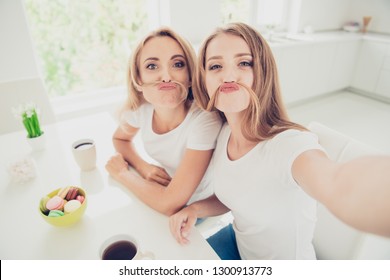 Self-portrait of two nice cute lovely sweet attractive charming cheerful cheery people blonde mom mum mommy enjoying free time in modern light white interior room - Powered by Shutterstock