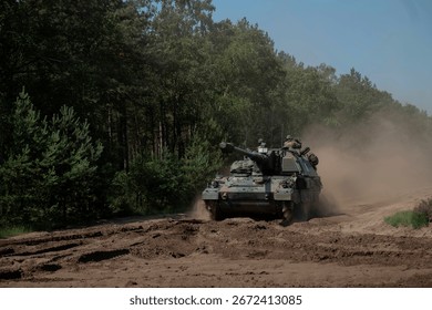 Self-propelled howitzer generating dust cloud during intensive field training