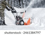 The self-propelled snow-plough blower. The man in warm clothes gloves instead of the big shovel has chosen a self-propelled engine snowplow outdoors white snow