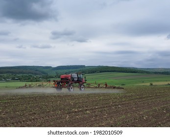 Self-propelled Sprayer Working In The Field During Spring In Romania. Applying Pesticides On A Young Corn Field.