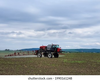 Self-propelled Sprayer Working In The Field During Spring In Romania. Applying Pesticides On A Young Corn Field.