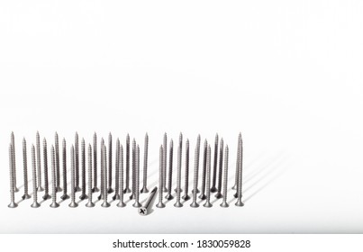 self-tapping screws in black are lined up in three rows on a white background. place for text.