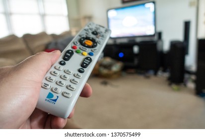 Selinsgrove, PA - April 15, 2019 - Close-up Of A Directv Remote In Hand Pointed At A TV. Selective Focus And Shallow Depth Of Field - Image