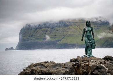 Selkie,The Statue of Kopakonan. ‘The Seal woman’., Faroe Islands. The legend of Kópakonan is one of the best-known folktales in the Faroe Islands.This is a 9 ft bronze steel statue in Mikladalur - Powered by Shutterstock